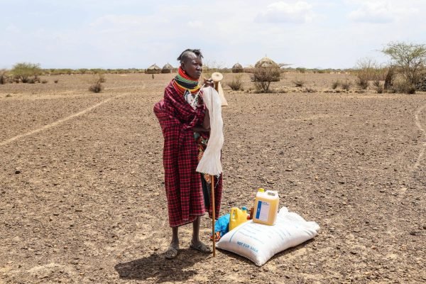 ARCHIVO - Una mujer se ve junto a su racion de comida tras un reparto de ayuda en el poblado de Nalemkais, condado de Turkana, Kenia, el 8 de febrero de 2026. (AP Foto/Patrick Ngugi, Archivo)